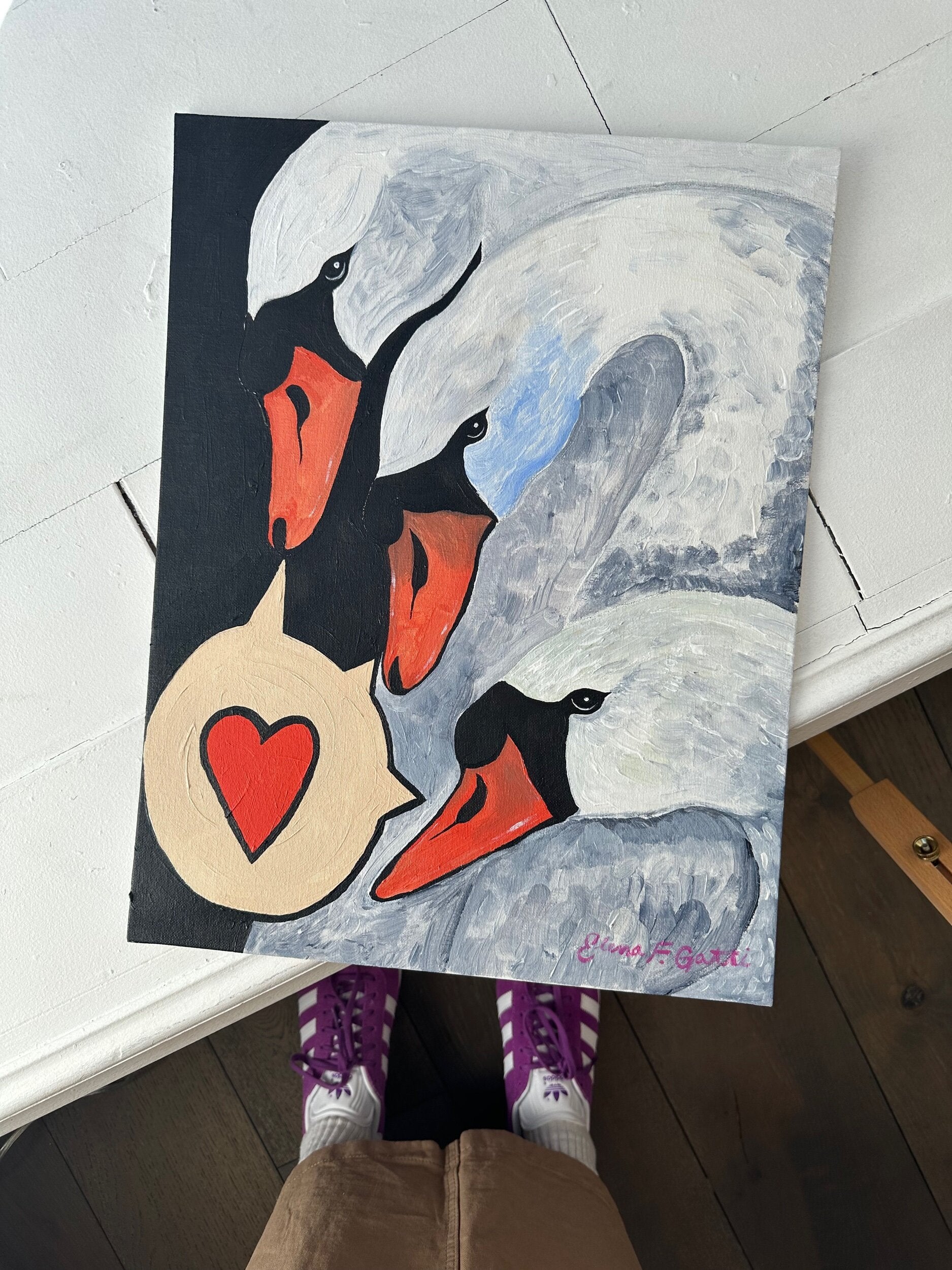a trio of swans with a speech bubble that contains a heart